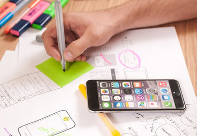 close up of someone sketching mobile wireframes